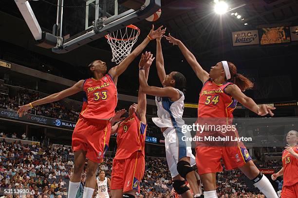 Chasity Melvin of the Washington Mystics drives to the basket against Angelina Williams, Kamila Vodichkova and Plenette Pearson of the Phoenix...