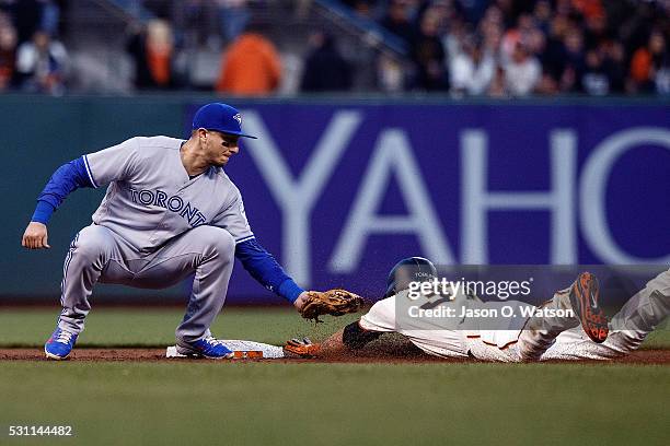 Kelby Tomlinson of the San Francisco Giants is tagged out attempting to steal second base by Troy Tulowitzki of the Toronto Blue Jays during the...