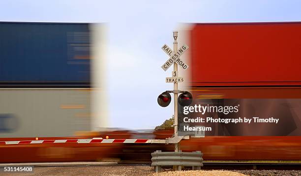 close up view of colorful train cars speeding through an intersection - train de marchandises photos et images de collection