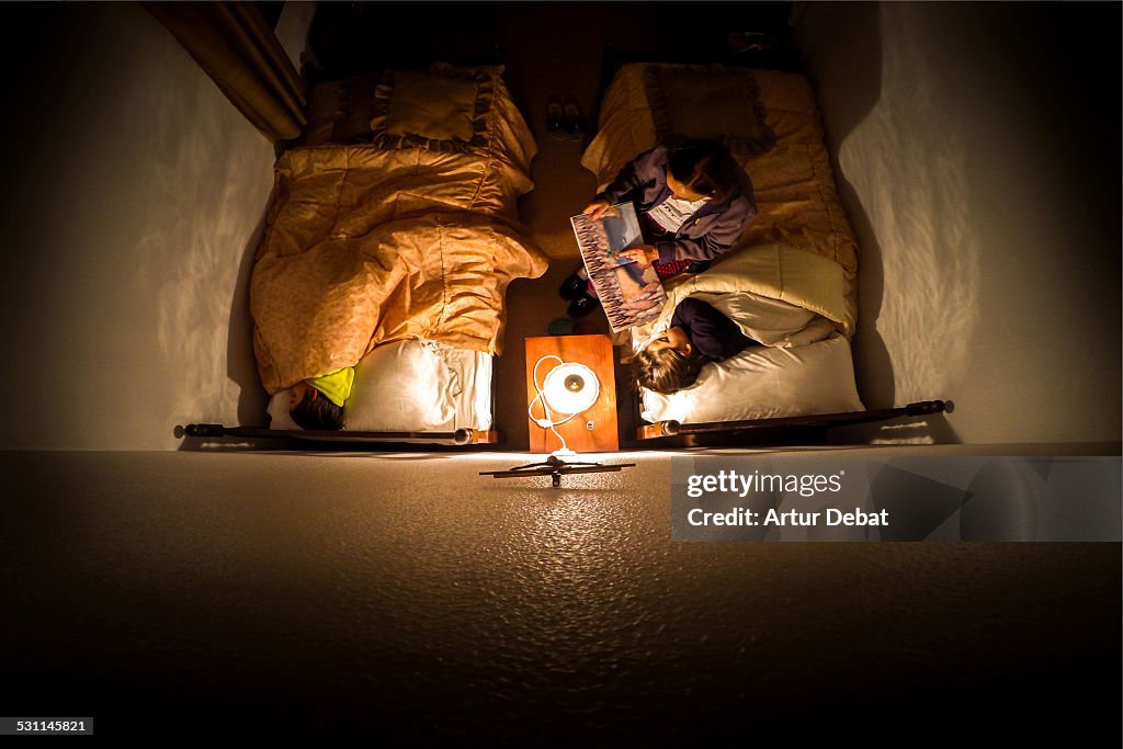 Grandma telling a night tale to grandsons at home.