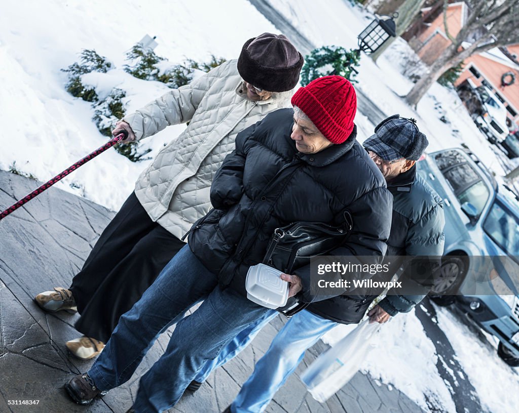 Senior Woman And Elderly Parents Walking From Car