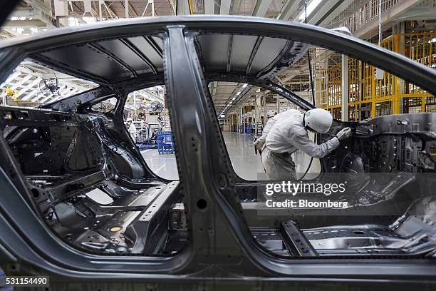 An employee finishes the welding on the frame of a Honda Civic vehicle on the production line of the Honda Motor Co. Assembly plant in Prachinburi,...