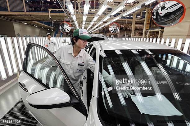 Employees check a Honda Civic vehicle at the quality control station on the production line of the Honda Motor Co. Assembly plant in Prachinburi,...