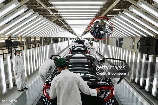 Employees check Honda Civic vehicles at the quality control station on the production line of the Honda Motor Co. Assembly plant in Prachinburi,...