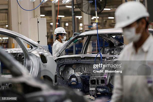 An employee finishes a welding joint on the frame of a Honda Civic vehicle on the production line of the Honda Motor Co. Assembly plant in...