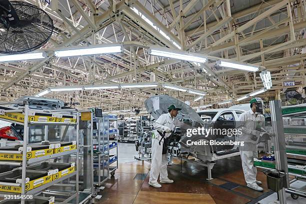 Employees work a Honda Civic vehicle on the production line of the Honda Motor Co. Assembly plant in Prachinburi, Prachinburi Province, Thailand, on...