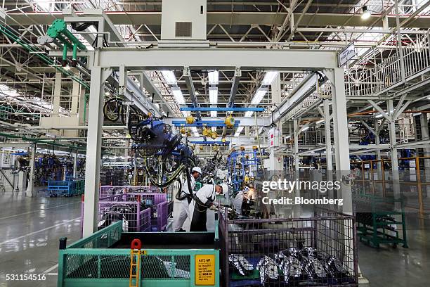 Employees operate welding machinery while working a part for a Honda Civic vehicle on the production line of the Honda Motor Co. Assembly plant in...
