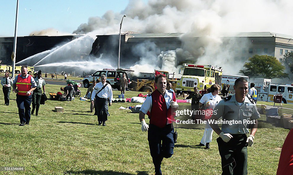 Workers attend to people while the flames are controlled at the Pentagon