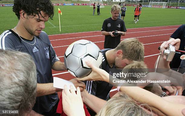 Film Director and former professional football player Soenke Wortmann films Michael Ballack signs autographs after the training session of the German...