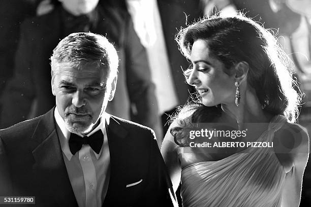 Actor George Clooney and his wife, British-Lebanese lawyer Amal Clooney leave on May 12, 2016 the Festival Palace after the screening of the film...