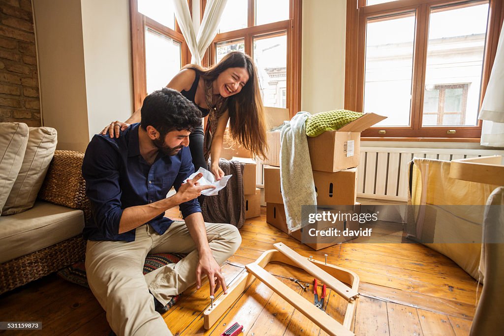 Couple Having Fun Moving In and Assembling Furniture