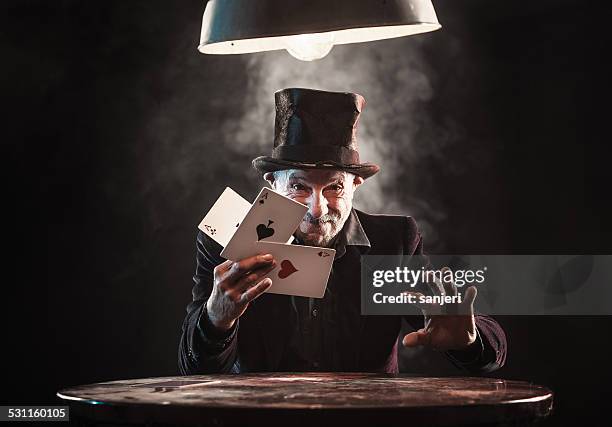 senior man making trick with playing cards - magician stockfoto's en -beelden