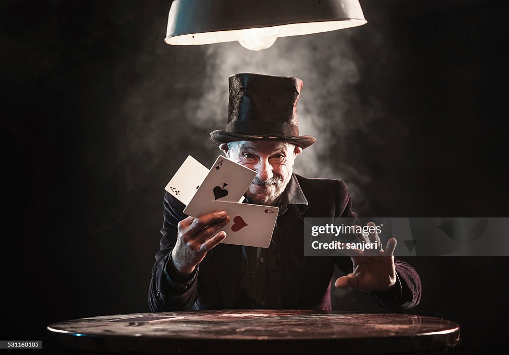 Senior man making trick with playing cards