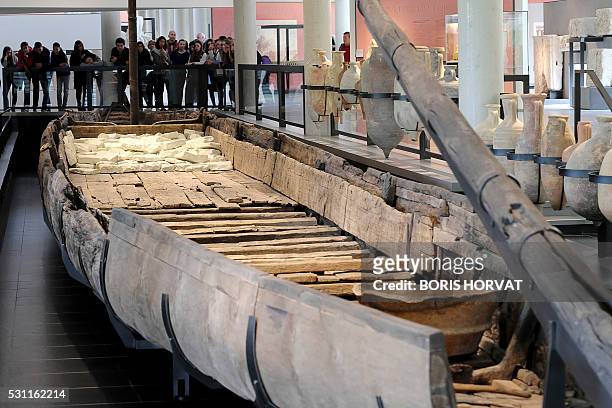Visitors look at a gallo-roman barge which French archaeologist Luc Long discovered in the River Rhone in 2007, on April 21, 2016 at the...