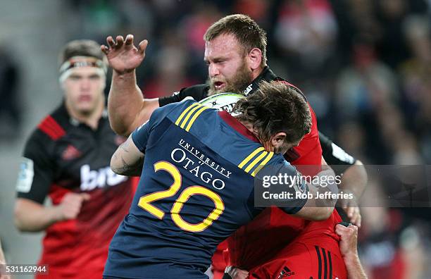 Joe Moody of the Crusaders is hit hard in a tackle by Liam Squire of the Highlanders during the round twelve Super Rugby match between the...