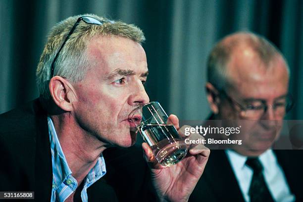 Michael O'Leary, chief executive officer of Ryanair Holdings Plc, left, drinks from a glass of water as Richard Pym, chairman of Allied Irish Banks...