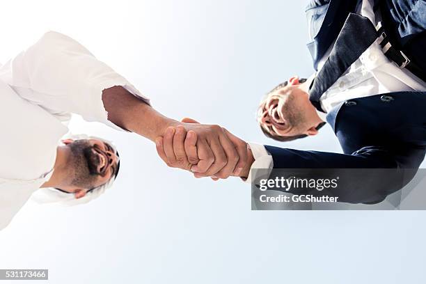 middle eastern man and european business man shaking hands - arab community life bildbanksfoton och bilder