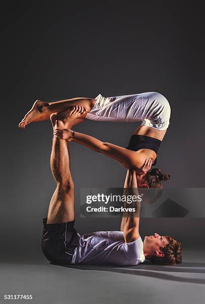 couple practicing acro yoga - acroyoga stock pictures, royalty-free photos & images