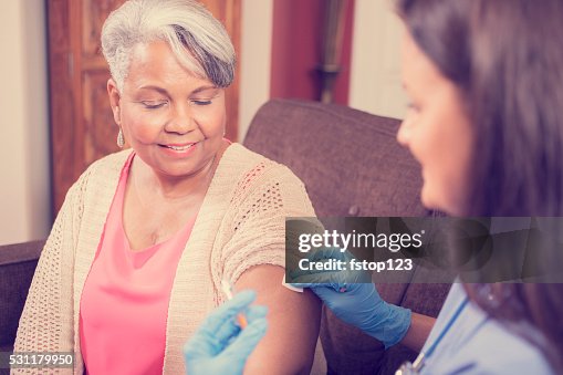 Home healthcare nurse giving injection to senior adult woman. Home healthcare nurse giving injection to senior adult woman.