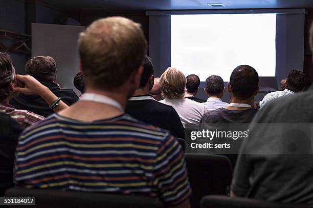 crowd audience looking at blank screen - auditorium presentation stock pictures, royalty-free photos & images