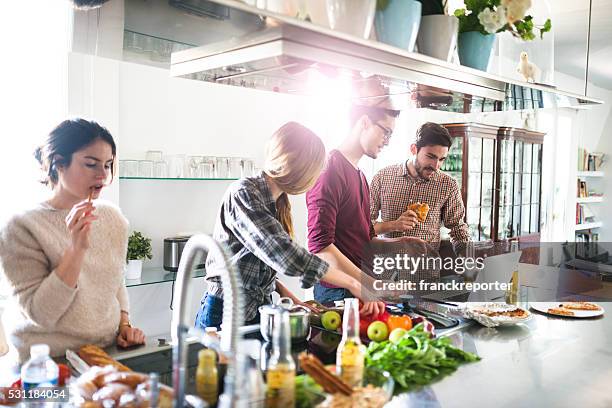 eine gruppe von freunden essen in der küche, die zubereitung von speisen - kochen freunde stock-fotos und bilder