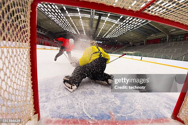 ice hockey goalie defending at penalty shot - hockey goal stockfoto's en -beelden