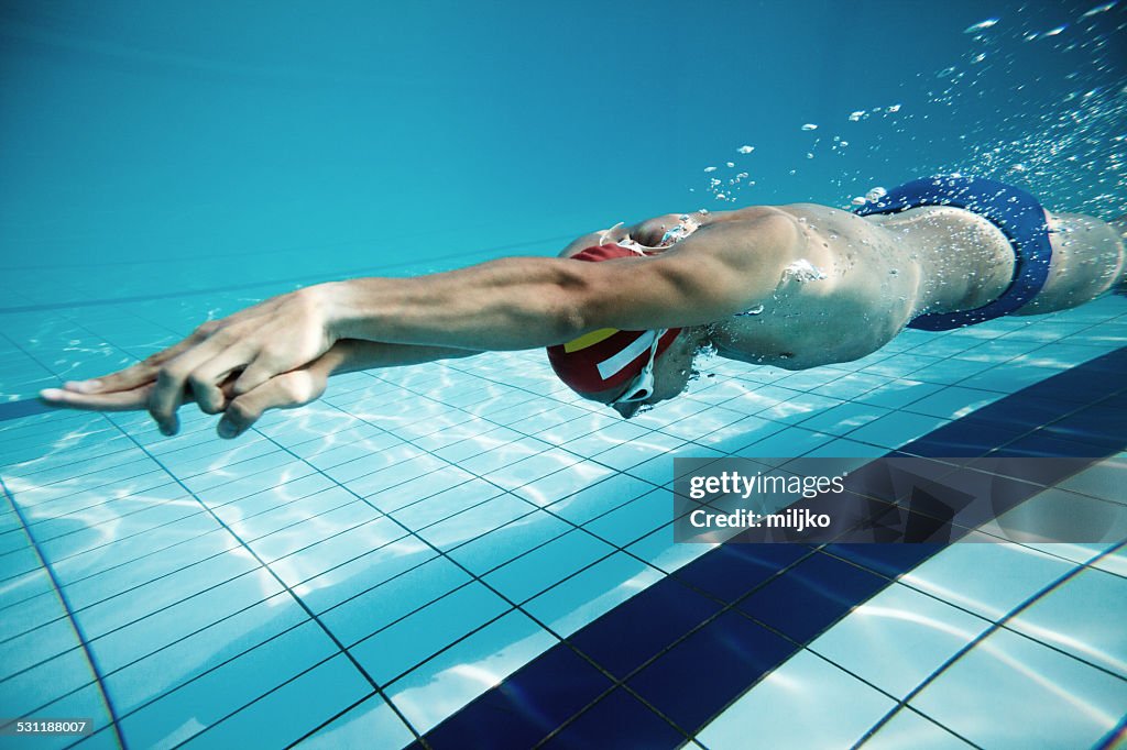 Swimmer diving after the jump in swimming pool