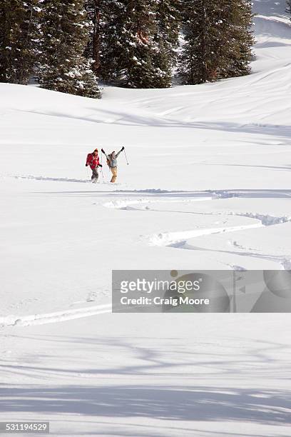a man and woman backcountry skiing near big sky, montnana. - gallatin county montana stock pictures, royalty-free photos & images