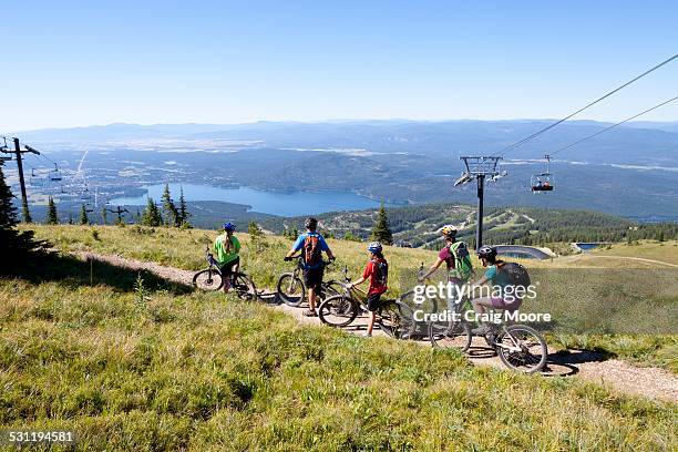 a family rides their bikes in whitefish, montana. - lake whitefish stock-fotos und bilder