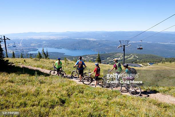 a family rides their bikes in whitefish, montana. - lake whitefish stock pictures, royalty-free photos & images