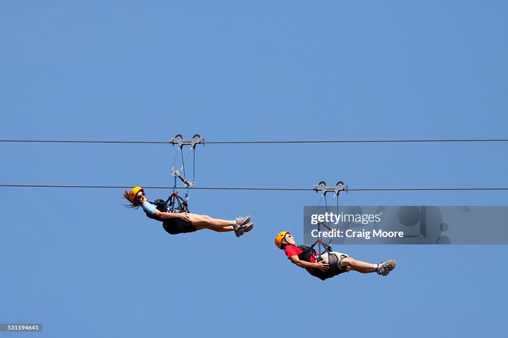 Two women ride a zip line in Whitefish, Montana.
