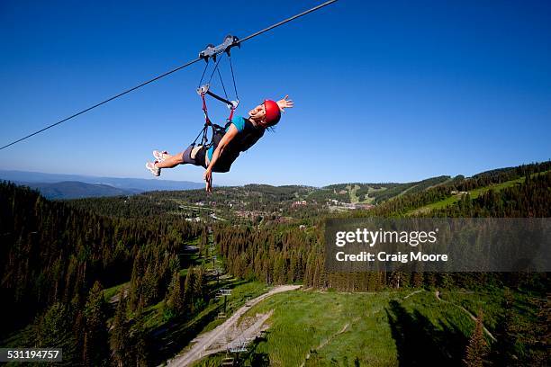 woman on a zip line smiling - zip line stock-fotos und bilder