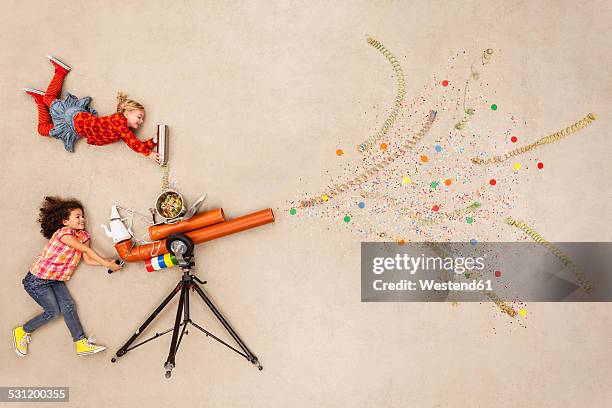 girls firing confetti cannon - kanon stockfoto's en -beelden