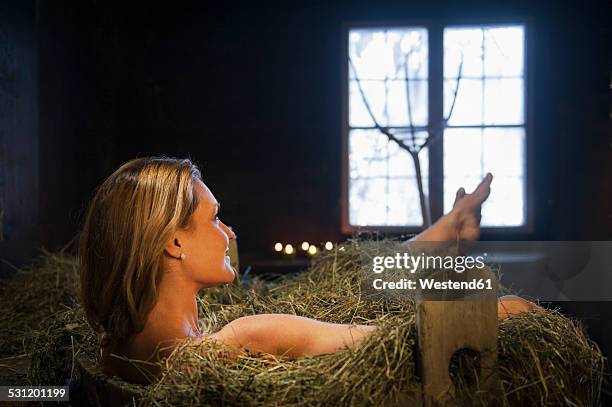 woman taking hay bath in a tub - hay stock pictures, royalty-free photos & images