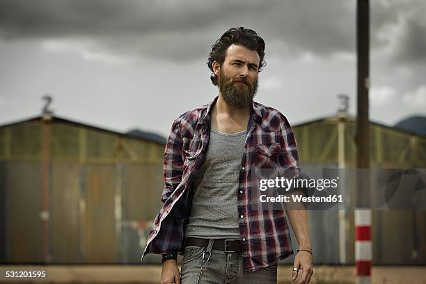 serious man with full beard in abandoned landscape - tough stock pictures, royalty-free photos & images