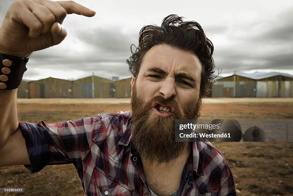 Angry man with full beard shouting at camera