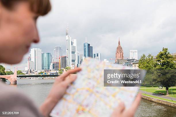 germany, hesse, frankfurt, businesswoman reading city map - hesse germany stock-fotos und bilder