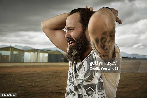 man with full beard in abandoned landscape - rock musician stock pictures, royalty-free photos & images