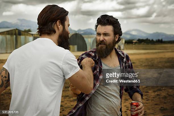 wo men with full beards fighting in abandoned landscape - vechten stockfoto's en -beelden