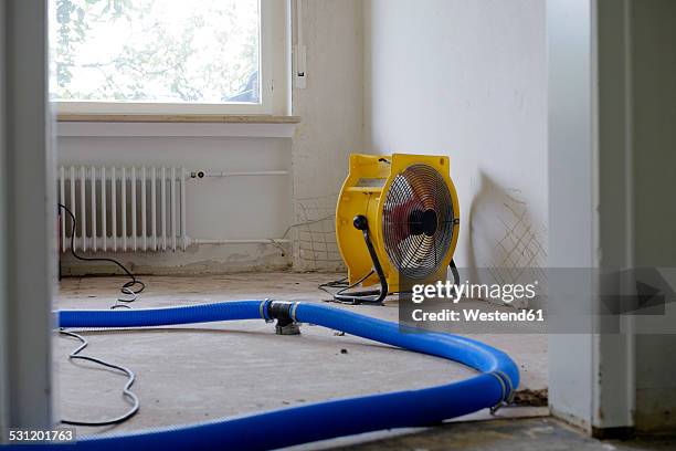 dehumidifier at work in an apartment which is damaged by flooding - house flood stock pictures, royalty-free photos & images