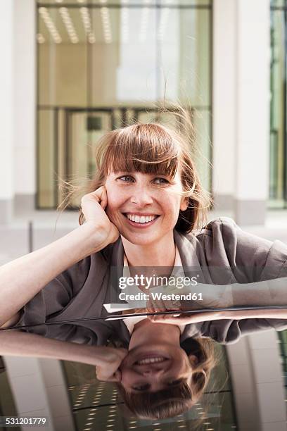 germany, hesse, frankfurt, portrait of smiling businesswoman leaning on car roof - double facepalm stock pictures, royalty-free photos & images