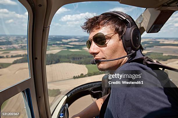 germany, bavaria, landshut, helicopter pilot in cockpit - helicopter pilot stock pictures, royalty-free photos & images