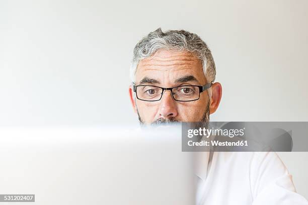 portrait of astonished businessman working at laptop - portrait of business man looking surprised stock-fotos und bilder