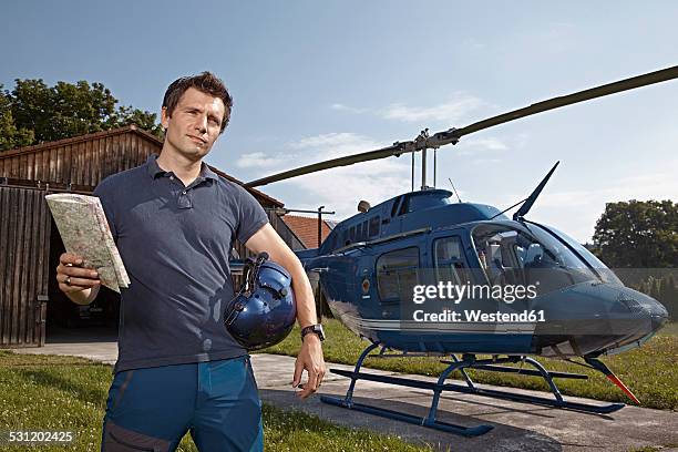 germany, bavaria, landshut, helicopter pilot holding map - helicopter pilot stock pictures, royalty-free photos & images