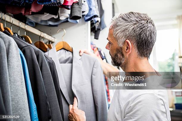 man choosing clothes at his walk-in closet - placard fotografías e imágenes de stock