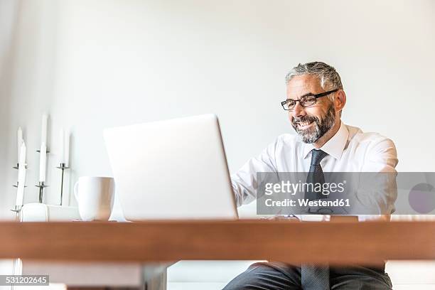 portrait of smiling businessman working at home office - corporate portraits depth of field stock pictures, royalty-free photos & images