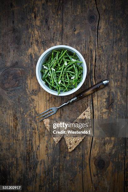 bowl of saltwort salad and rye crackers on dark wood - marsh samphire photos et images de collection