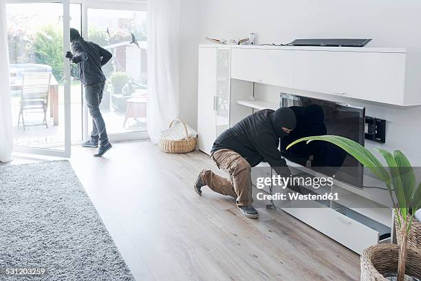 two burglars at work in an one-family house at daytime - roubando crime - fotografias e filmes do acervo