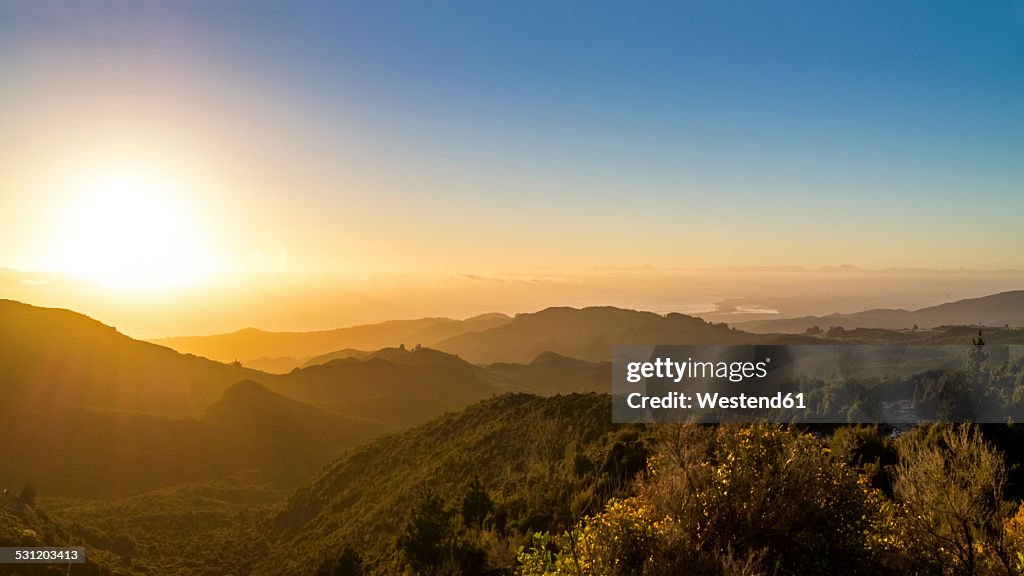 Australia, Queensland, sunrise above the ocean seen from mountains