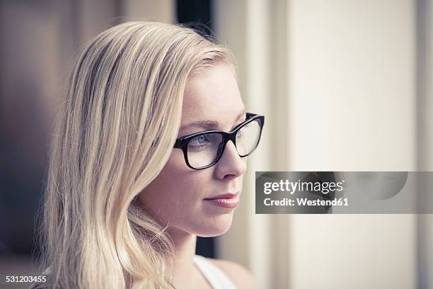 portrait of young woman wearing glasses - デサチュレート ストックフォトと画像